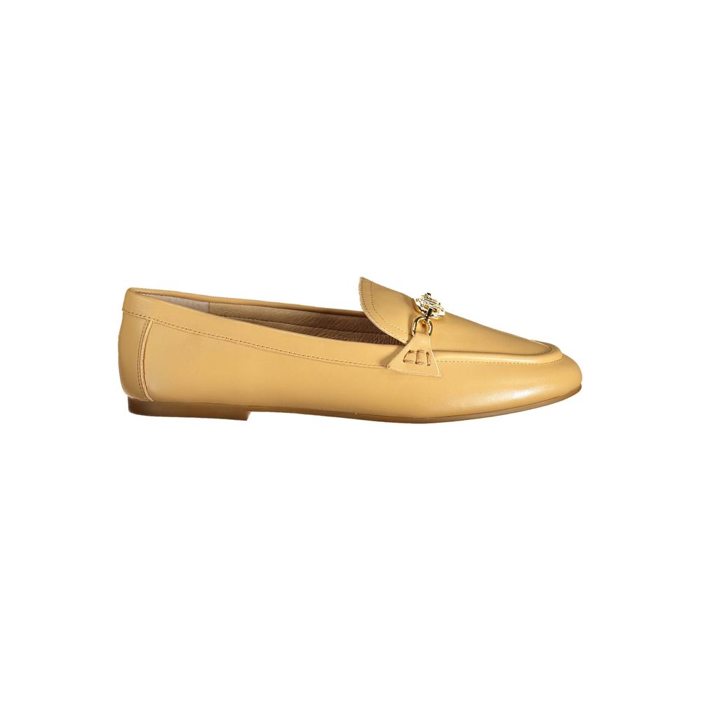 Yellow loafer shoe with a decorative buckle on a white background