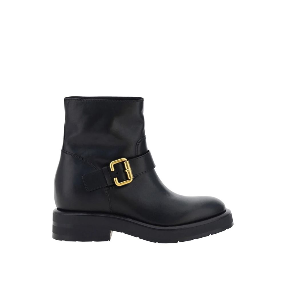Black boot with a gold buckle on a white background