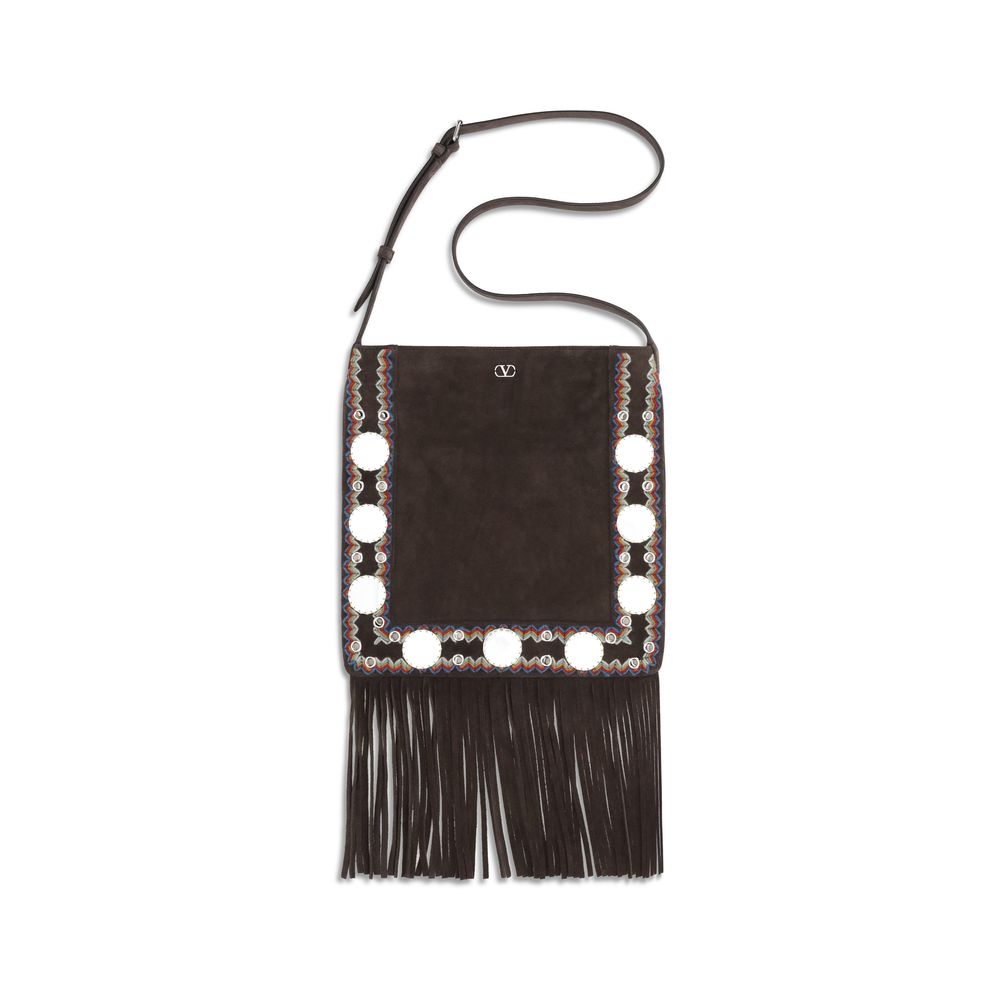 Black handbag with fringe and decorative elements on a white background